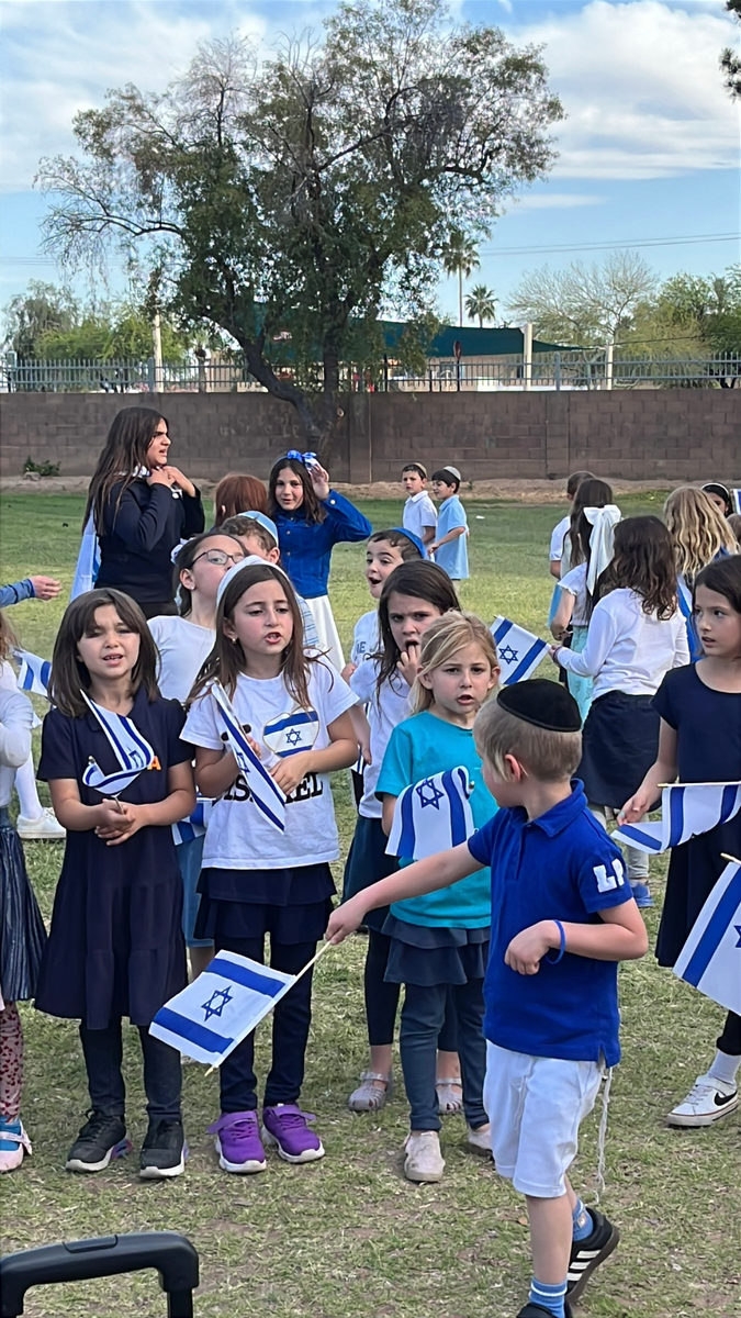 PHA girls waving Israeli flags at a school celebration